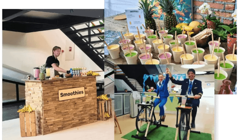 Two guests pedaling the Smoothie Bike to create a fresh smoothie during an interactive event wellness experience.
