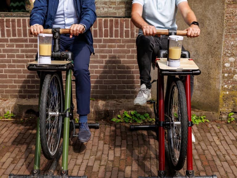 A guest pedaling the Smoothie Bike to create a fresh smoothie during an interactive event wellness experience.